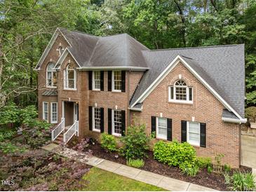 Traditional brick home with a well-manicured lawn and mature trees at 1004 Staffield Lane Ln, Chapel Hill, NC 27516