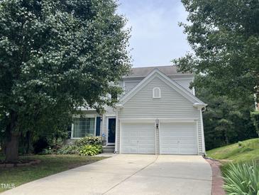Charming two-story home featuring a two-car garage and well-maintained front yard, framed by mature trees at 122 Button Rd, Morrisville, NC 27560
