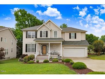 Charming two-story home with a manicured front yard, covered porch, and attached two-car garage at 1480 Big Leaf Loop, Apex, NC 27502