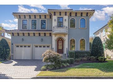 Stunning two-story home features a stucco exterior, arched windows and a charming front balcony at 15 Treviso Pl, Durham, NC 27707