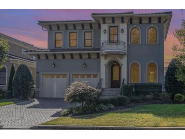 Stately two-story home featuring a two-car garage, balcony, arched windows, and well-maintained landscaping at 15 Treviso Pl, Durham, NC 27707
