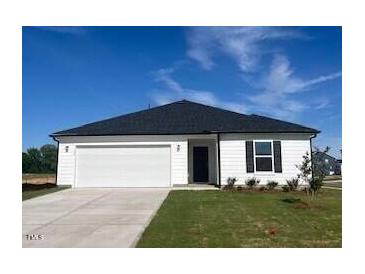 Charming single-story home with a two-car garage, manicured lawn, and a classic black and white color scheme at 16 Vale Spring Ln, Lillington, NC 27546