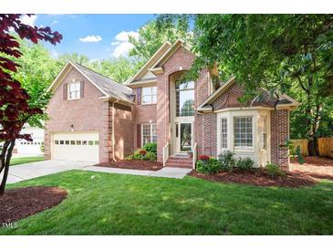 Charming two-story brick home featuring a well-manicured lawn and an attached two car garage at 216 Lewey Brook Dr, Cary, NC 27519