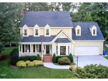 Charming two-story home with a manicured lawn, brick walkway, and attached two car garage at 2645 Ridgewell Ct, Raleigh, NC 27613