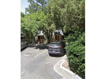 Charming two-story home with red door nestled among lush greenery and a parking area at 300 Cedarwood Ln, Carrboro, NC 27510