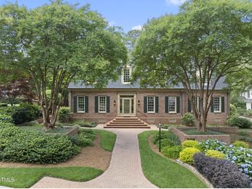 Traditional brick home with manicured landscaping, mature trees, and inviting brick pathway at 4109 City Of Oaks Wynd, Raleigh, NC 27612