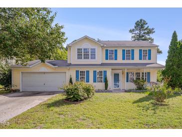 Charming two-story home with blue shutters and a well-manicured lawn, offering classic curb appeal at 7024 Beaverwood Dr, Raleigh, NC 27616
