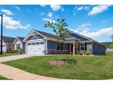 Charming single-Gathering home featuring a red front door, well-manicured lawn, and attached two-car garage at 75 Springwood Ln, Franklinton, NC 27525