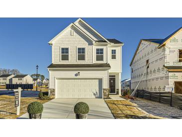 Charming two-story home with a two-car garage and manicured front yard under a clear blue sky at 136 N Finley Landing Parkway, Smithfield, NC 27577