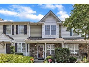 Charming townhome featuring a stone facade and manicured landscaping at 3806 Bison Hill Ln, Raleigh, NC 27604