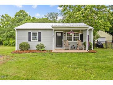Charming single story home with a manicured lawn and a cozy front porch with rocking chairs at 4048 B S Nc 62 Hwy, Burlington, NC 27215