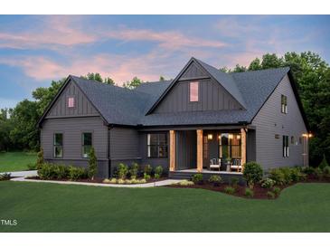 Charming home featuring a covered porch with wooden columns and well-manicured landscaping at 4628 Rogers Rd, Wake Forest, NC 27587