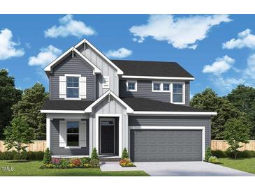 Charming two-story home with a gray exterior, white trim, and a two-car garage in a well-manicured community at 62 Restful Point, Fuquay Varina, NC 27526