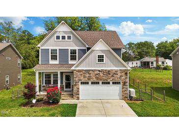 Charming two-story home featuring stone accents, a two-car garage, and manicured lawn at 635 Black Angus Dr, Haw River, NC 27258