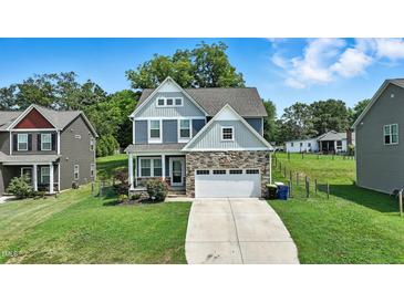 Charming two-story home with stone accents, a well-manicured lawn, and an attached two-car garage at 635 Black Angus Dr, Haw River, NC 27258