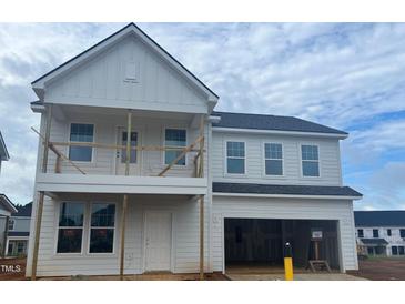 Two-story home showcasing the modern design with neutral siding, covered porch, and an attached two-car garage at 682 Old Station Pointe, Angier, NC 27501