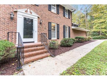 Charming brick home with a classic front entrance and black railing at 6824 Branton Dr, Cary, NC 27519