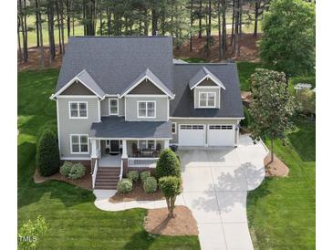 Inviting two-story home with a manicured lawn and a spacious driveway leading to a two-car garage at 925 Hidden Jewel Ln, Wake Forest, NC 27587