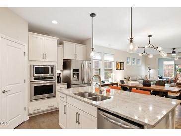 This is a well-appointed kitchen with stainless steel appliances, a granite countertop, and pendant lighting at 1008 Sounding Ln, Durham, NC 27703