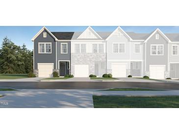 Charming townhome showcasing the exterior with gray siding, black front door and an attached garage at 1105 Weavers Trace Dr, Zebulon, NC 27597
