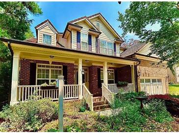 Charming two-story brick home featuring a welcoming front porch and beautiful landscaped yard, plus an attached garage at 12212 Ashton Woods Ln, Raleigh, NC 27614