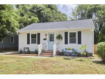 Charming single-story home with a light blue door, brick steps, and a cozy front yard seating area at 1408 Ida St, Durham, NC 27705
