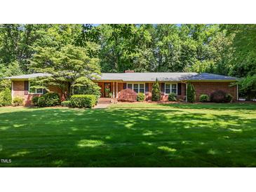 Charming brick home boasts a lush green lawn and mature trees, creating a welcoming curb appeal at 2053 Nottingham Ln, Burlington, NC 27215