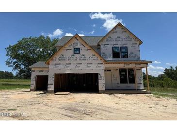 Unfinished two-story home with a two-car garage awaiting new construction to be completed at 209 Atkins Rd, Cameron, NC 28326