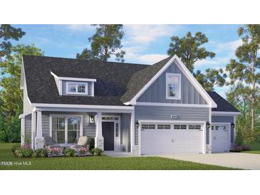 Charming home featuring a welcoming front porch, well-manicured lawn, and a convenient two-car garage at 235 Atkins Rd, Cameron, NC 28326
