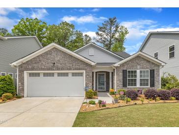 Charming single-story home featuring stone accents, a two-car garage, and a well-manicured lawn with beautiful landscaping at 2634 Yellow Pine Rd, Raleigh, NC 27616