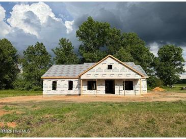An exterior elevation showcasing a partially built home with a yard and surrounding trees at 275 Atkins Rd, Cameron, NC 28326