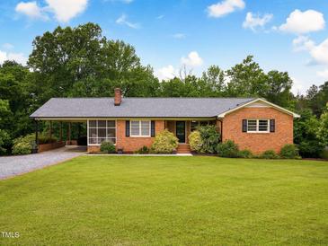 Charming brick home with a well-manicured lawn and covered carport perfect for enjoying the outdoors at 3906 Union Ridge Rd, Burlington, NC 27217