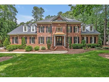 Elegant brick home with manicured lawn, black shutters, and a copper-roofed entrance at 8 Pine Top Pl, Durham, NC 27705