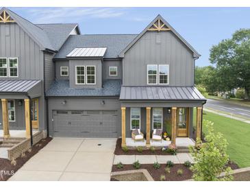 Stunning gray farmhouse-style home with a two-car garage, covered porch, and well-manicured landscaping at 1049 Coldspring Circle, Durham, NC 27705