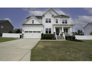 Charming two-story home featuring a white exterior, covered porch, and well-manicured lawn and a two car garage at 170 Kinsale Ct, Garner, NC 27529