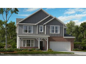 Charming two-story home featuring board and batten siding, a brick facade, and a welcoming covered front porch at 245 Tidal Pool Way, Cary, NC 27519