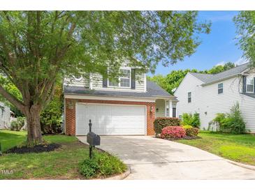 Charming home with a two-car garage, mature tree, landscaped yard, and brick accents at 248 Inkster Cv, Raleigh, NC 27603