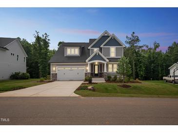 Beautiful two-story home with a two-car garage, manicured lawn, and inviting front porch at 271 W Amber Oak Dr, Selma, NC 27576