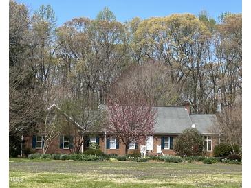 Charming brick home with lovely landscaping and a blooming tree in the front yard at 3110 Fieldstone Ln, Mebane, NC 27302
