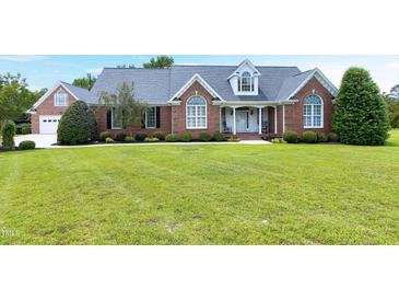 Charming brick home featuring a well manicured lawn and inviting front porch at 4005 Olde Waverly Way, Fuquay Varina, NC 27526