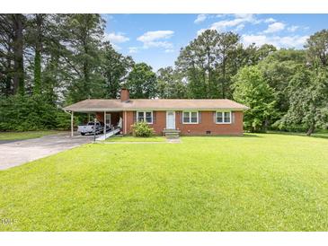Charming brick ranch home with a lush green lawn and a covered carport for convenient parking at 9751 N Highway 96, Selma, NC 27576