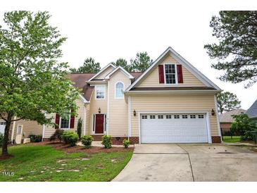 Charming two-story home features a well-manicured lawn, attached two-car garage, and inviting red front door at 10 London Way, Spring Lake, NC 28390