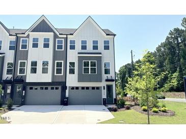 Modern townhome featuring a stylish gray and white exterior with ample windows and two-car garage at 1000 Regalia Rd # 1, Durham, NC 27713