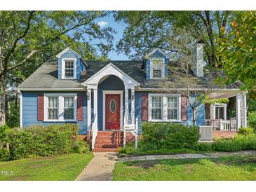 Charming blue home boasts a red front door, dormer windows, and brick steps leading to the entrance at 102 W Weatherspoon St, Sanford, NC 27330