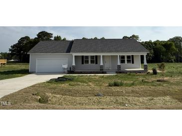 Charming single-story home featuring a welcoming front porch and attached garage at 111 Coharie Dr, Lillington, NC 27546