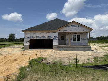 New construction features a modern facade, showcasing its architectural design and curb appeal on a sunny day at 136 Tuskeegee Dr, Smithfield, NC 27577