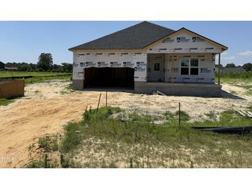 New construction home features a two-car garage, gray roof, and siding ready for a buyer's final touch at 136 Tuskeegee Dr, Smithfield, NC 27577