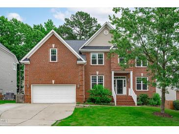Charming brick home with an attached garage, well-maintained lawn and beautiful landscape at 2003 Red Sage Ct, Apex, NC 27502