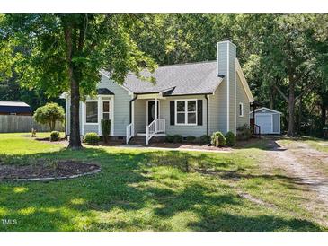 Charming single-story home featuring a well-manicured lawn and mature trees at 2213 Stephanie Ln, Clayton, NC 27520