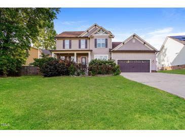 Charming two-story home features a manicured lawn and attached two car garage at 234 Lars Ln, Garner, NC 27529